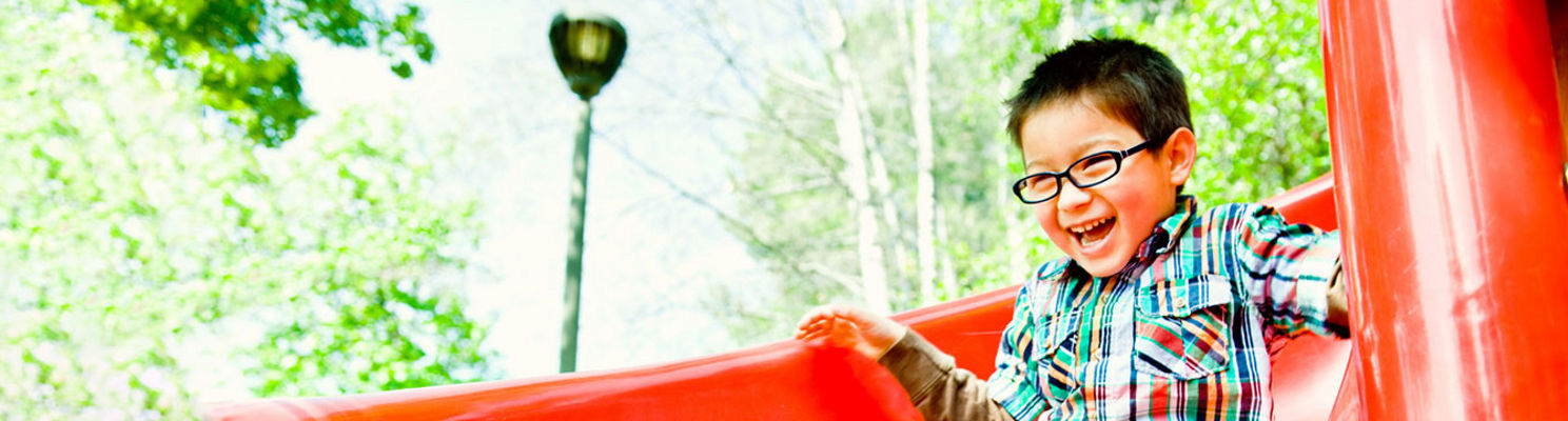 smiling boy on red slide