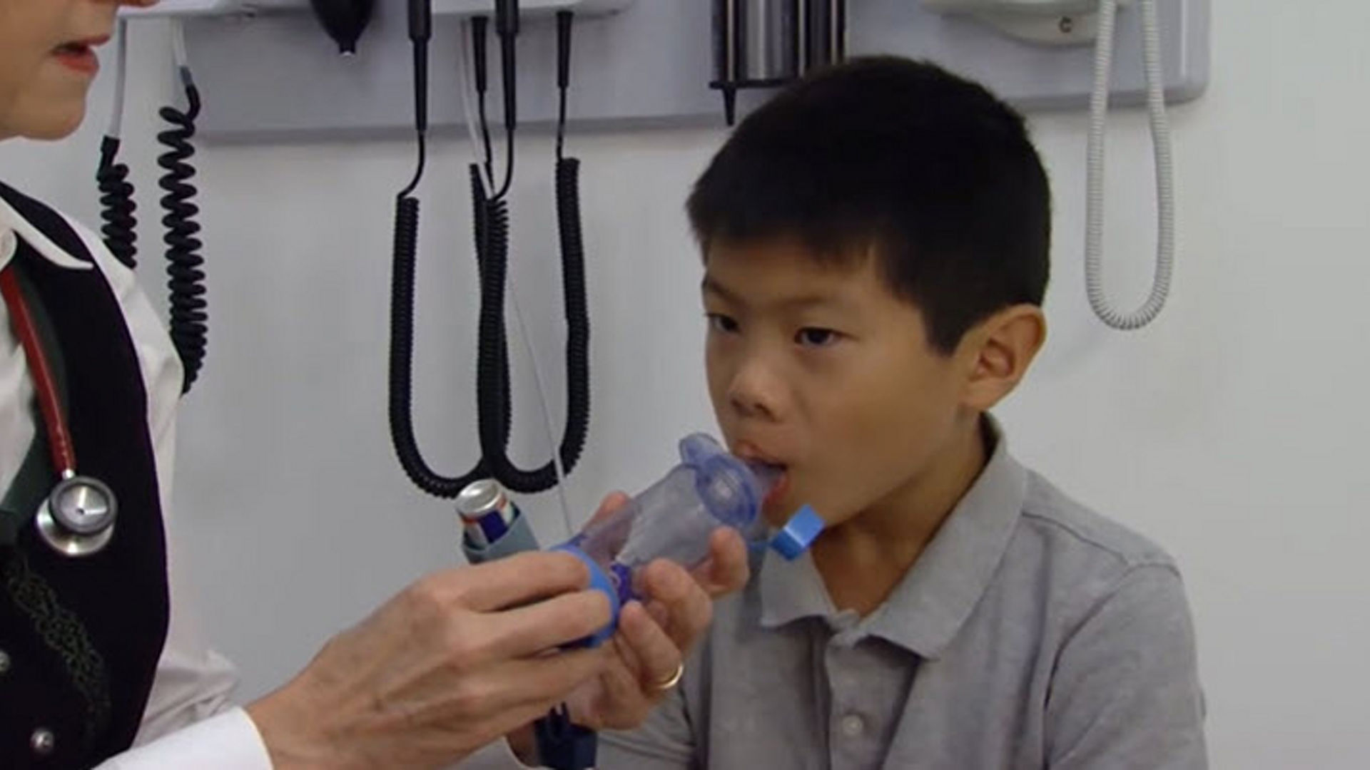 Child using a metered dose inhaler with a mouthpiece.