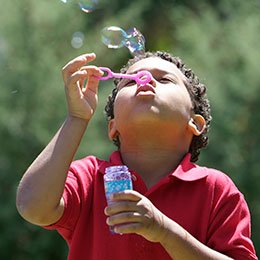 child blowing bubbles