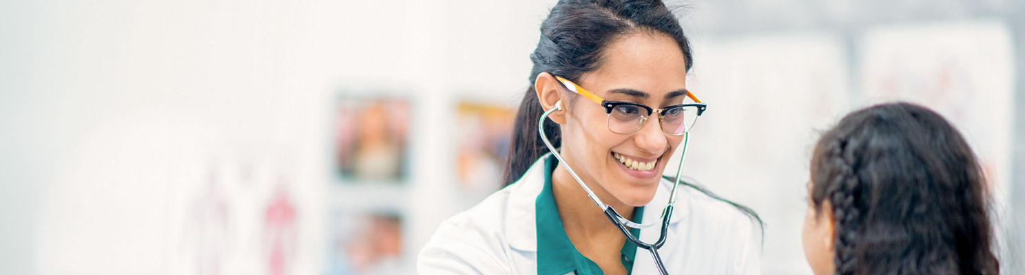 Doctora sonriendo con paciente pediátrica