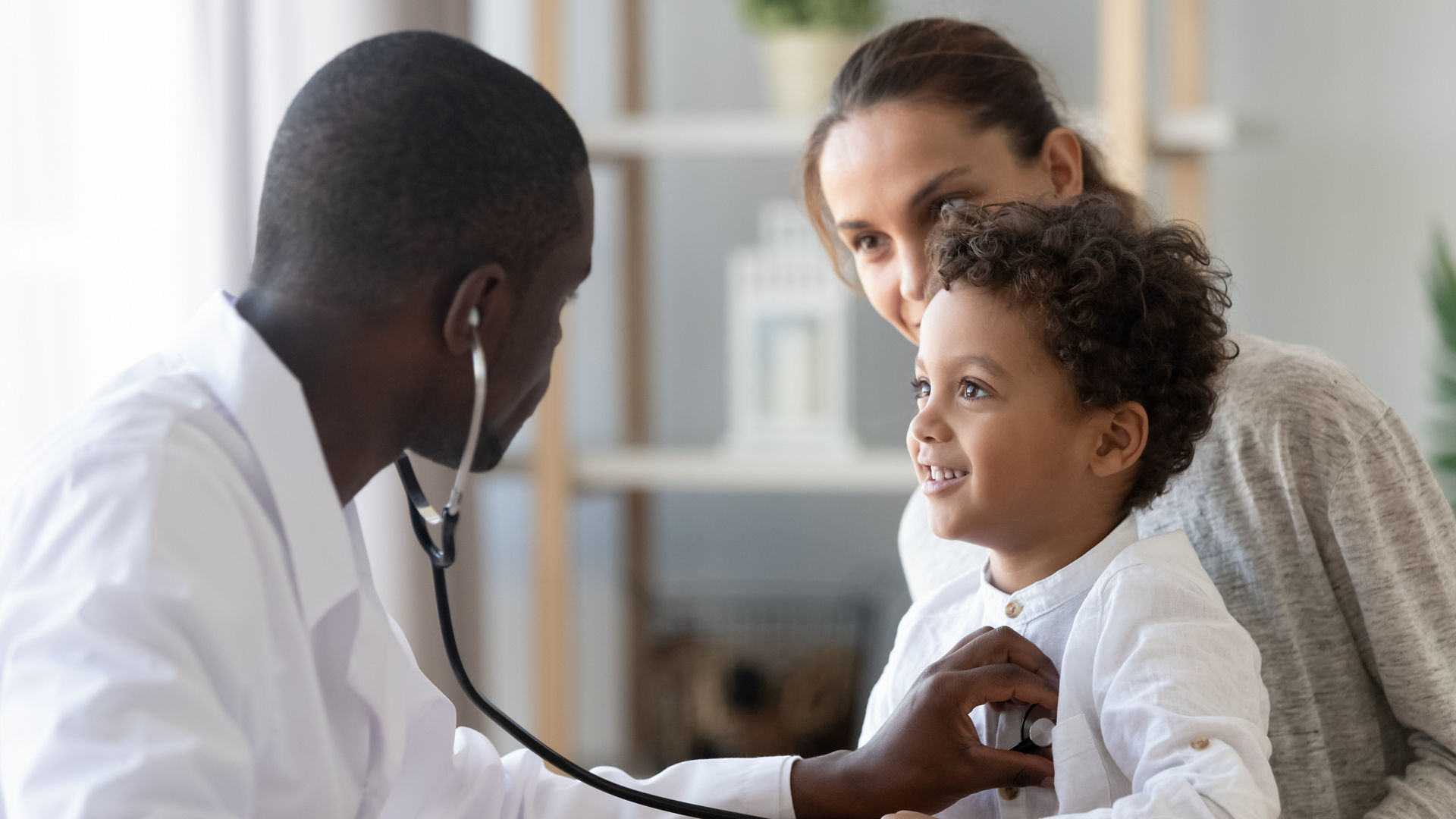 Doctor listening to young patient's heart