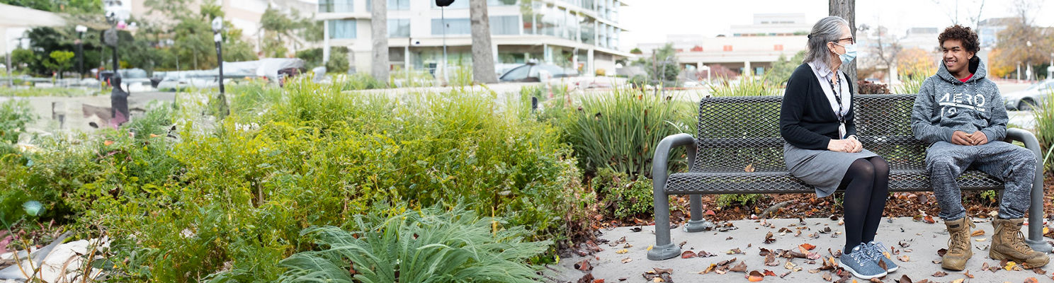 Young man and health provider sitting on bench