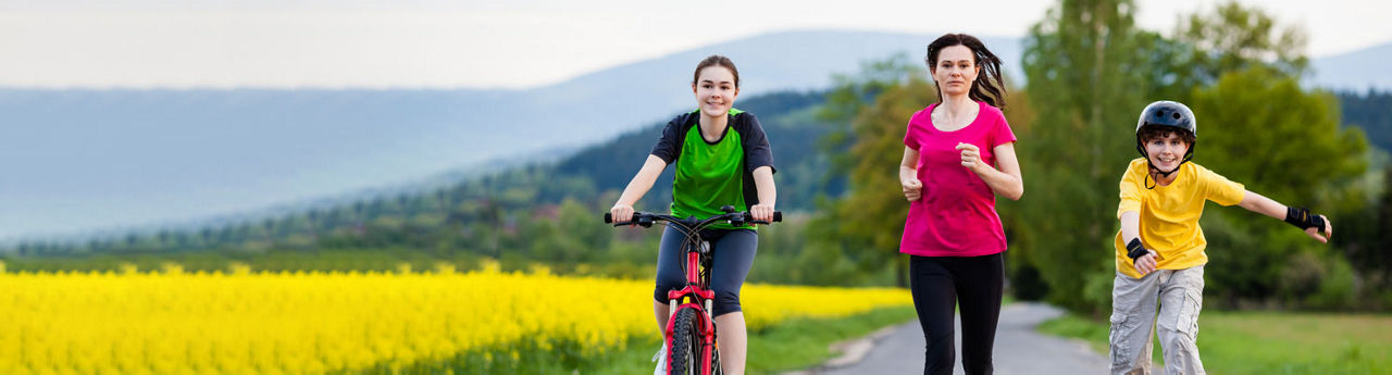 Family running and biking on road