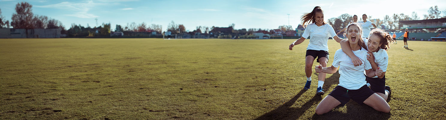 Girls sports team celebrating on the field