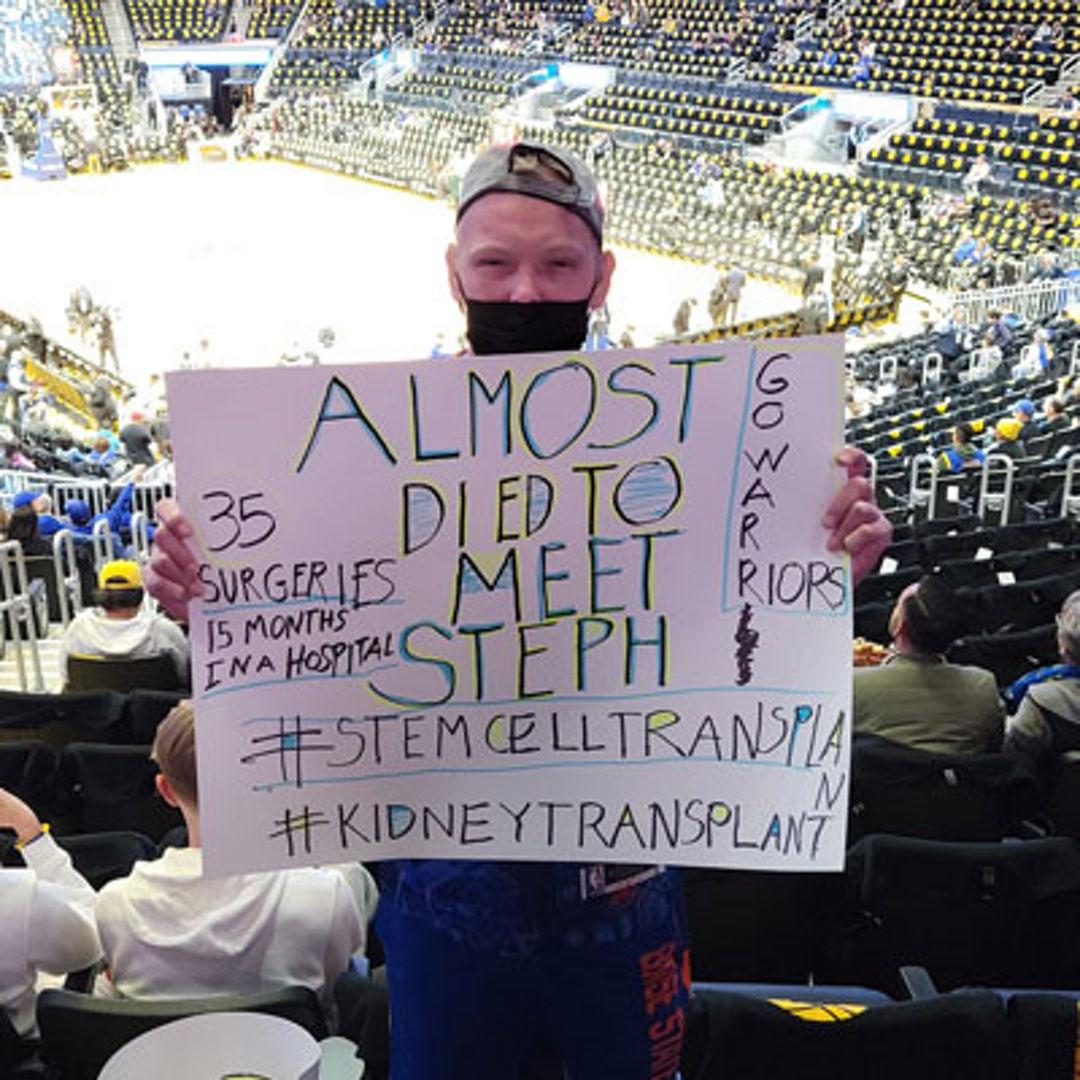 Traejen holding sign at Warriors game