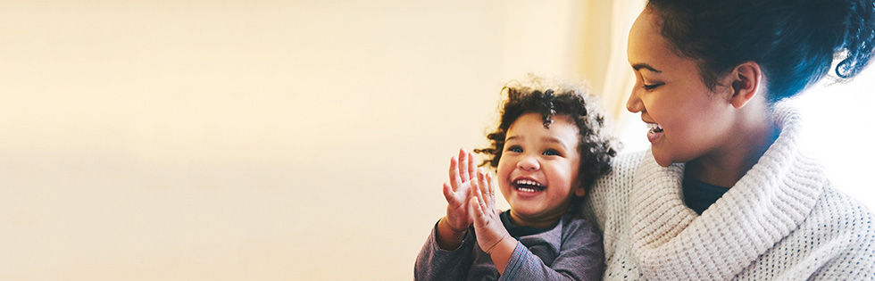 Smiling mother holding happy kid