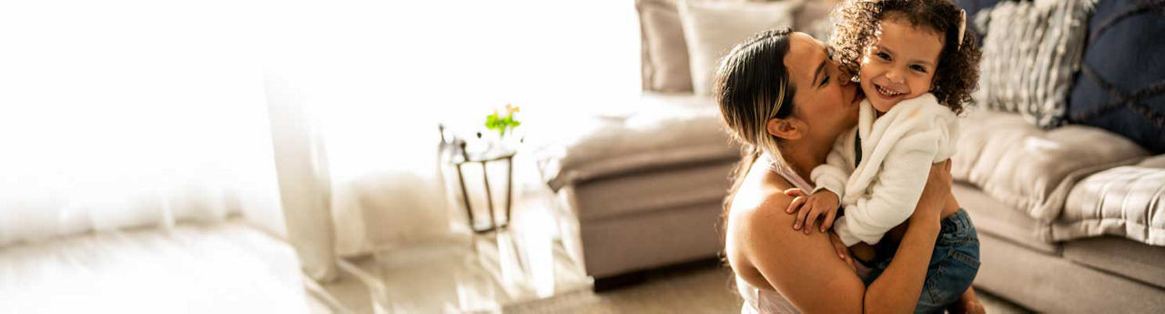 A toddler girl having fun with her mother in their living room at home