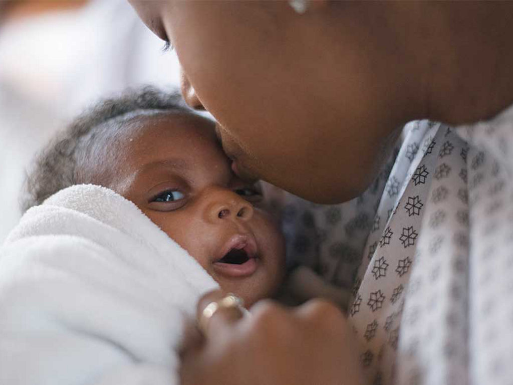 Mother kissing baby on forehead