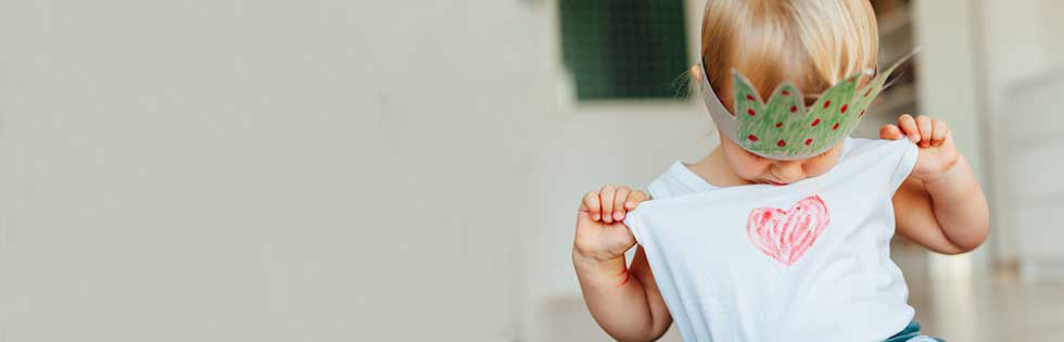 Niña mirando el corazón en la camisa