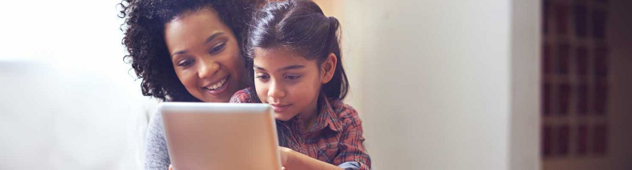 Mom and daughter looking at an iPad