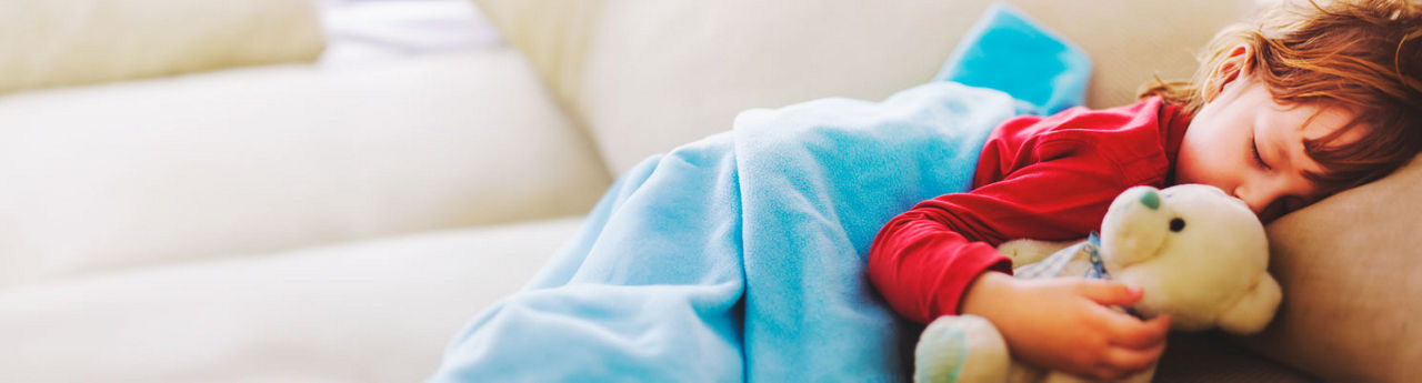 Child sleeps with teddy bear