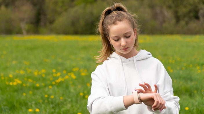 Teen outdoors with smartwatch
