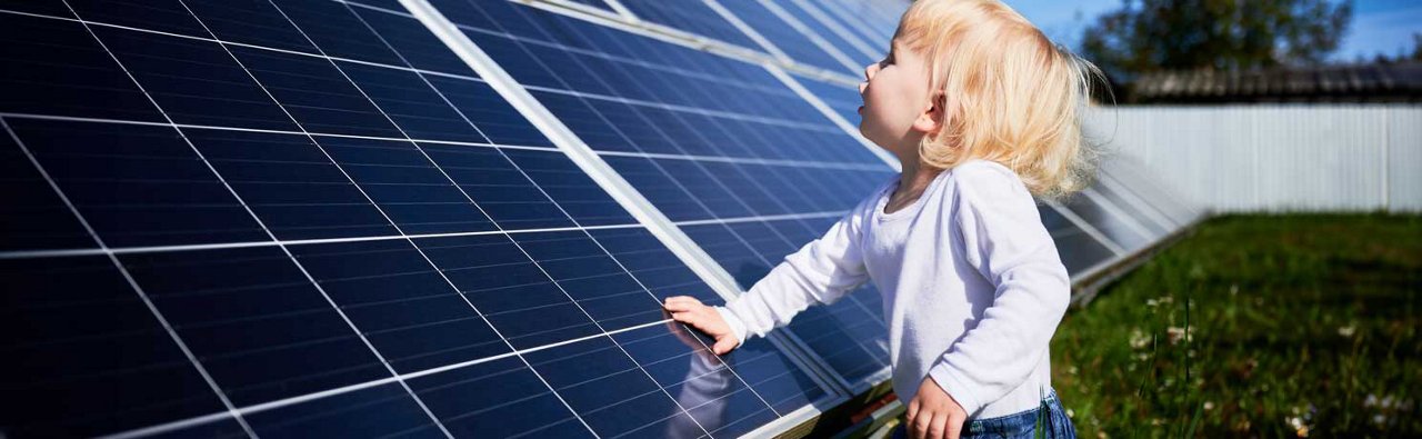 Young girl in front of solar panels