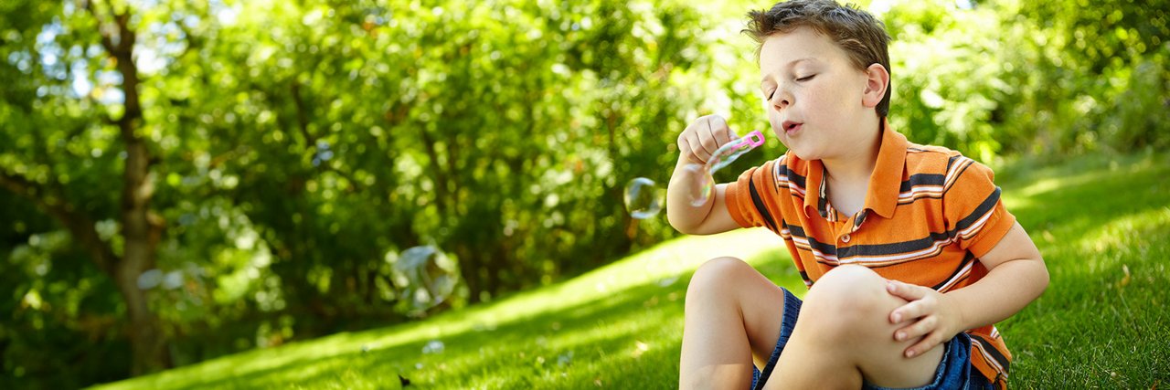 Young child blowing bubbles